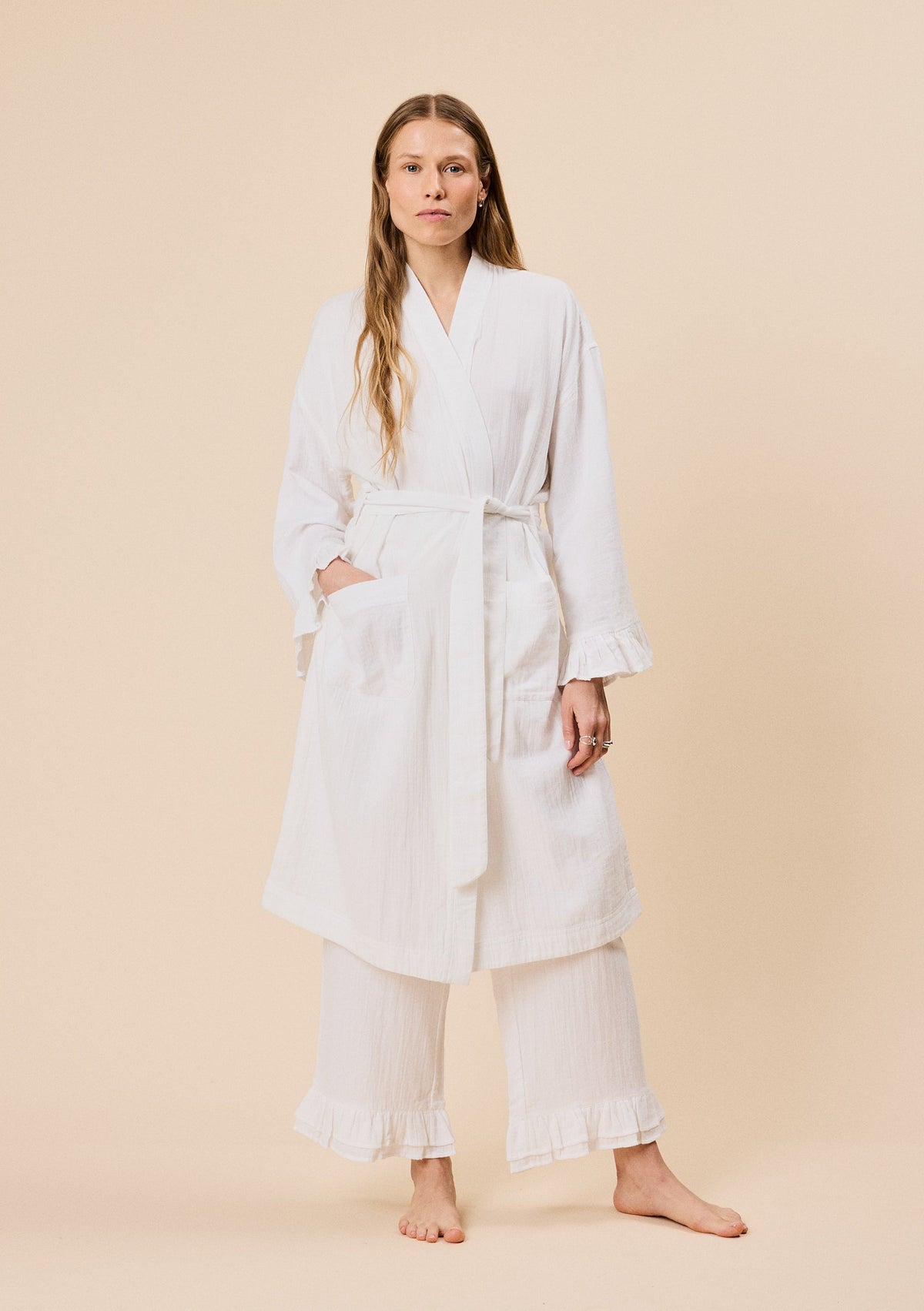 Woman wearing a white robe on a beige background