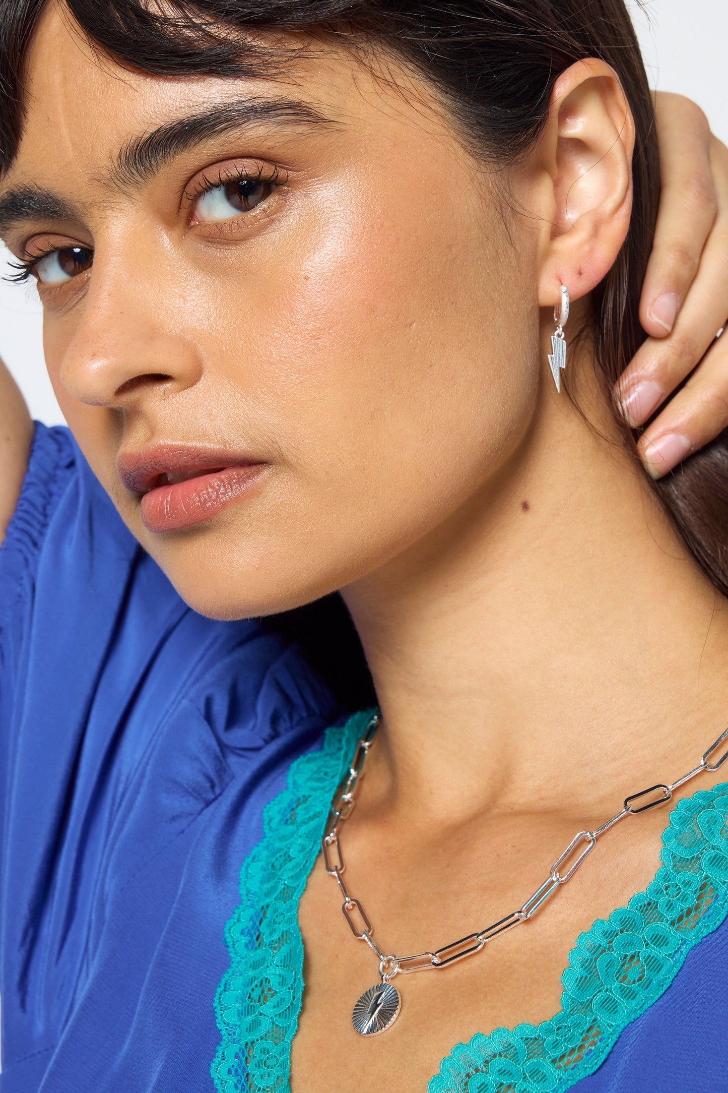 Silver lightning bolt huggie earrings.