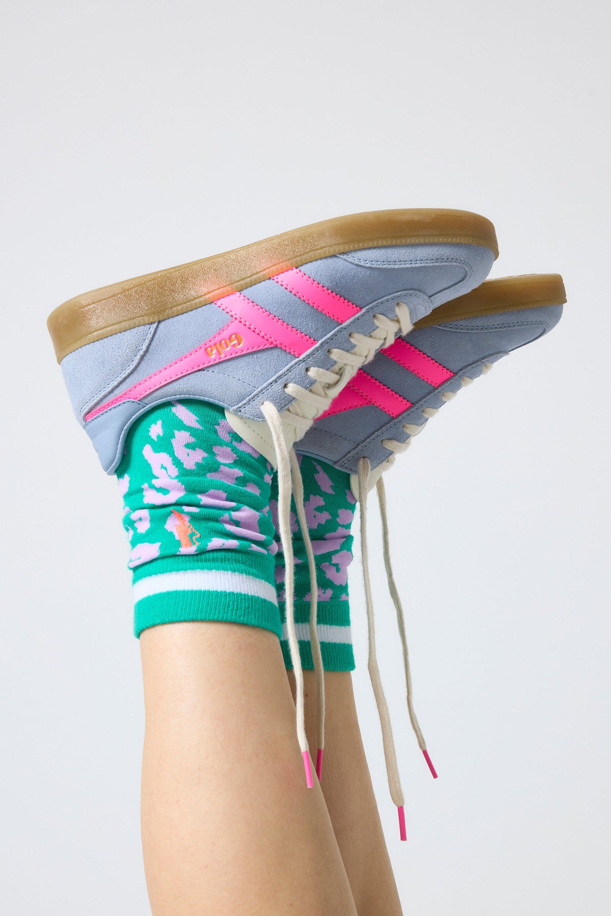 Light blue suede trainers with hot pink flash and Gola logo.