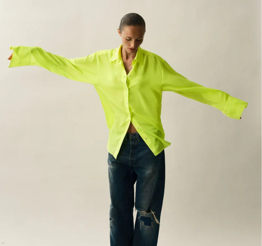 Person wearing a neon yellow satin shirt and jeans by Serena Bute, styled for the Clear Winter colour season by Shop My Palette.