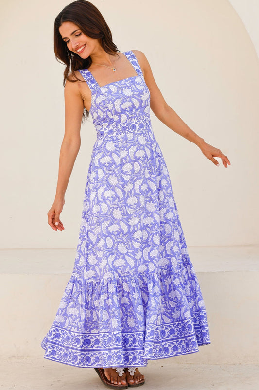 Lilac and white floral print maxi dress with square neckline, wide straps, fitted bodice, and tiered skirt.