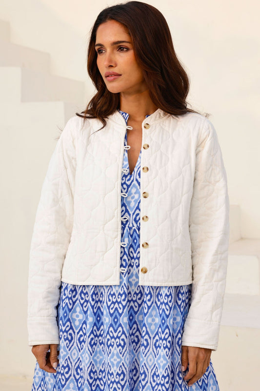 Off-white quilted jacket with round neckline, button front, and long sleeves.