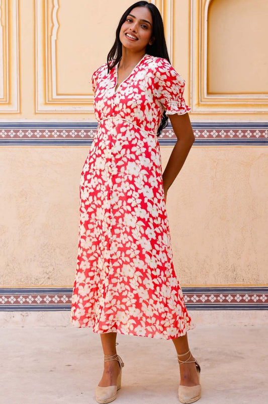 Coral red midi dress with white floral print, V-neckline, short puff sleeves, and fitted waist.