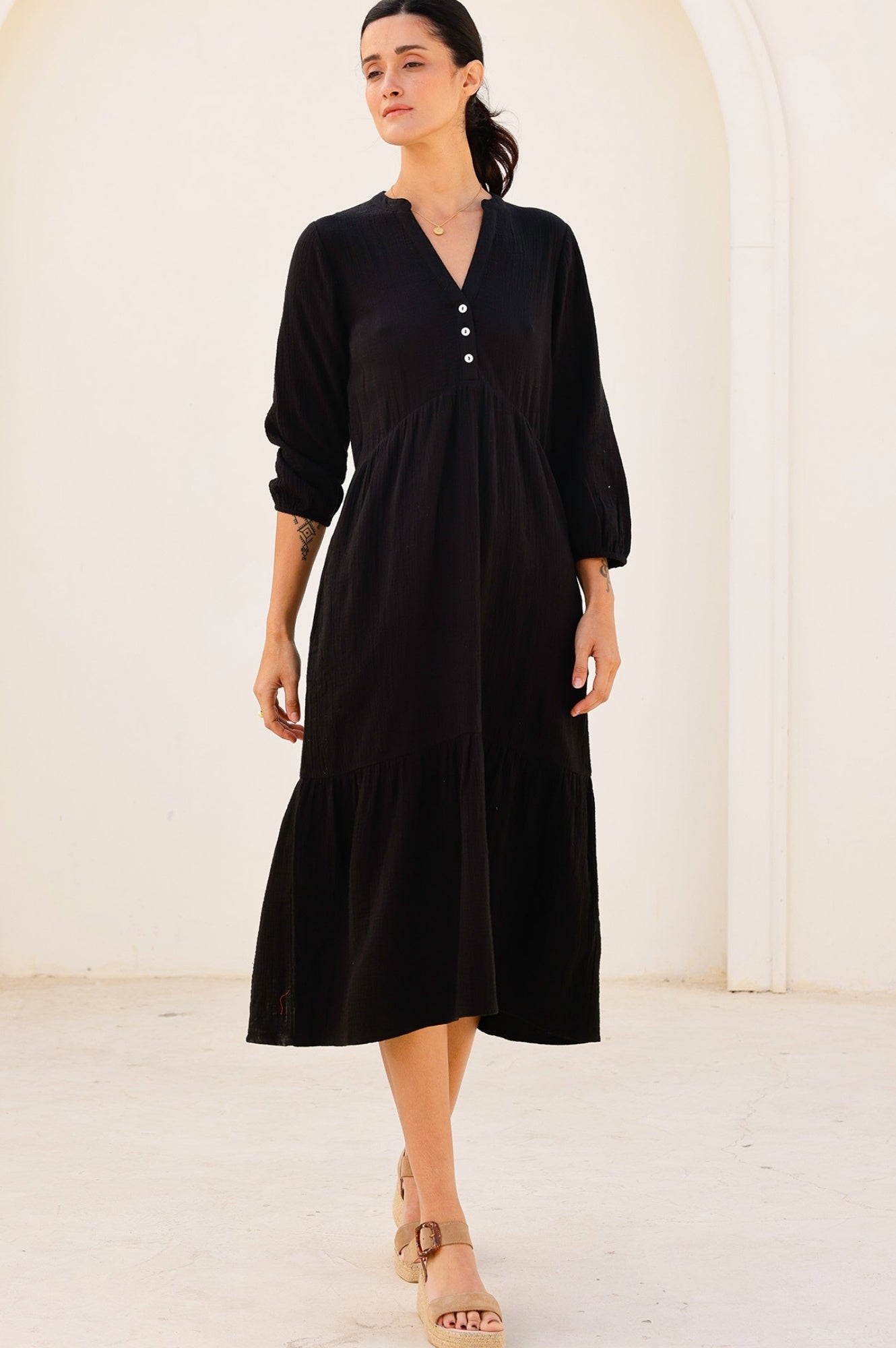 Black cheesecloth midi dress with V-neckline, button placket, long sleeves, and gathered waist.