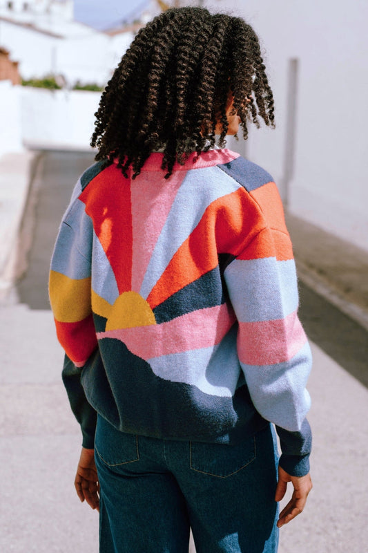 Knitted zip up cardigan with sunset pattern in red, blue, pink, yellow, and navy.