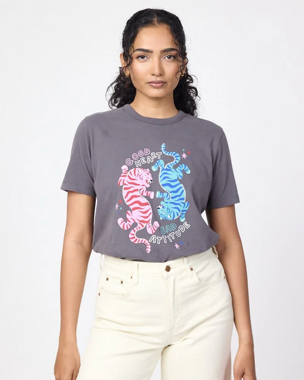 Woman wearing a muted grey t-shirt with cool and colourful tiger design and text saying "Good Heart, Bad Attitude".