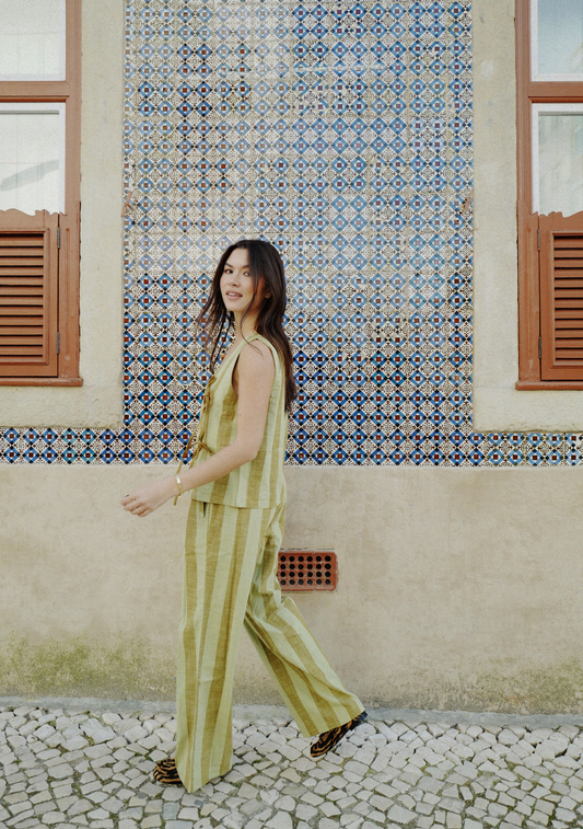 Green striped trousers with soft sage and olive vertical stripes, elasticated waistband, and relaxed straight-leg fit
