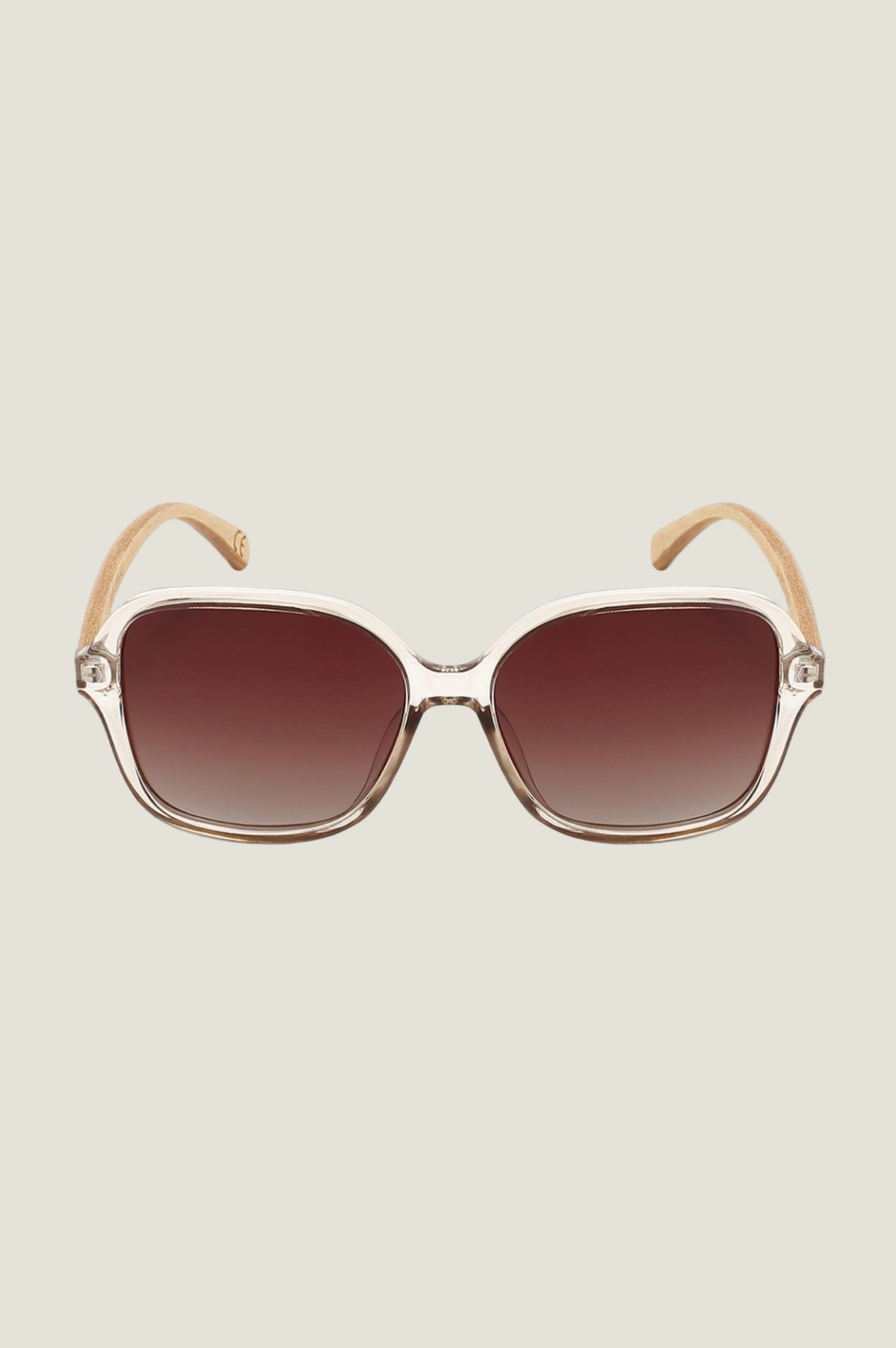Oversized square sunglasses with transparent beige frame and brown gradient lenses.
