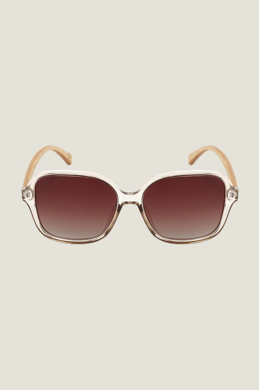 Oversized square sunglasses with transparent beige frame and brown gradient lenses.