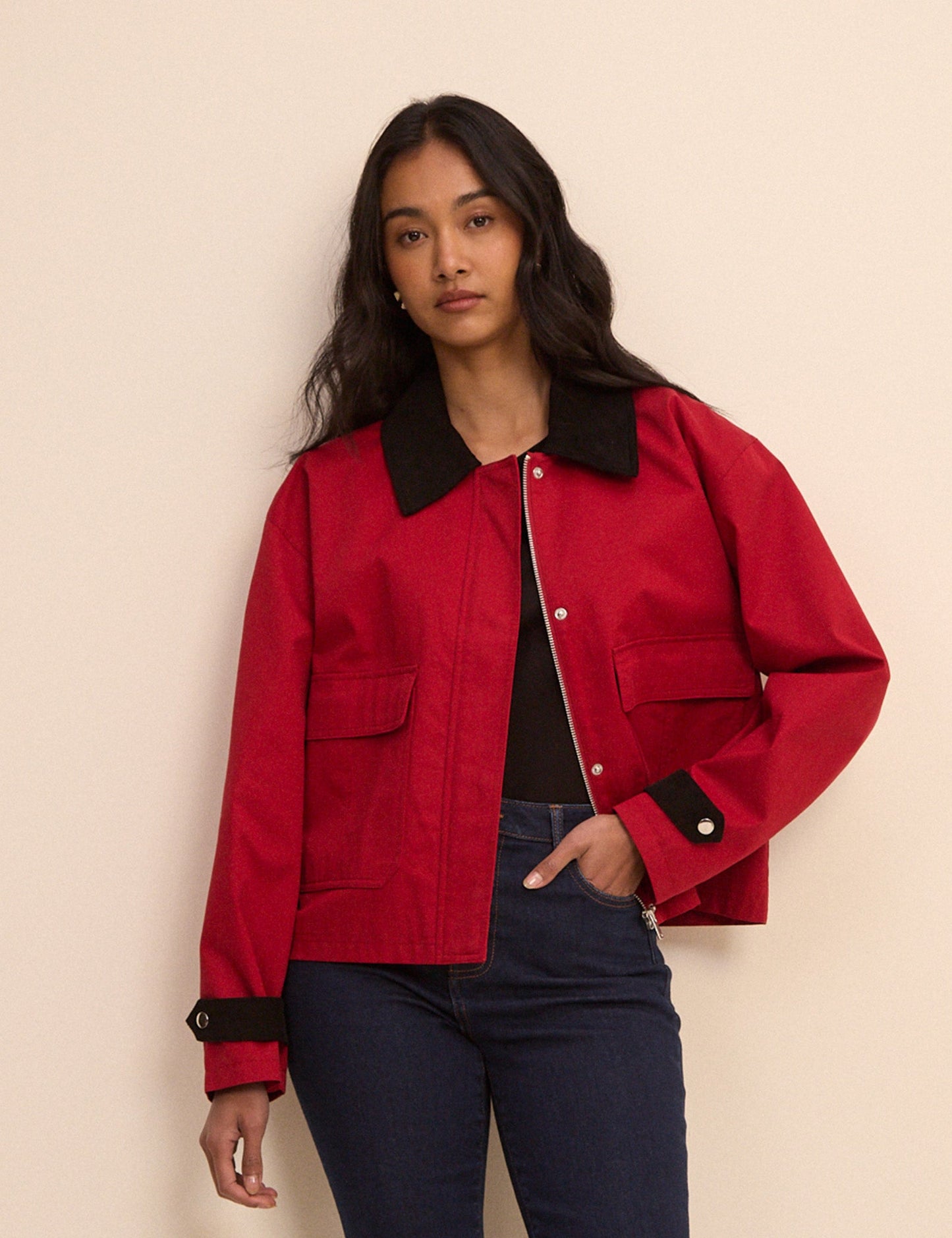 A cropped red barn jacket with contrasting black collar and cuffs.