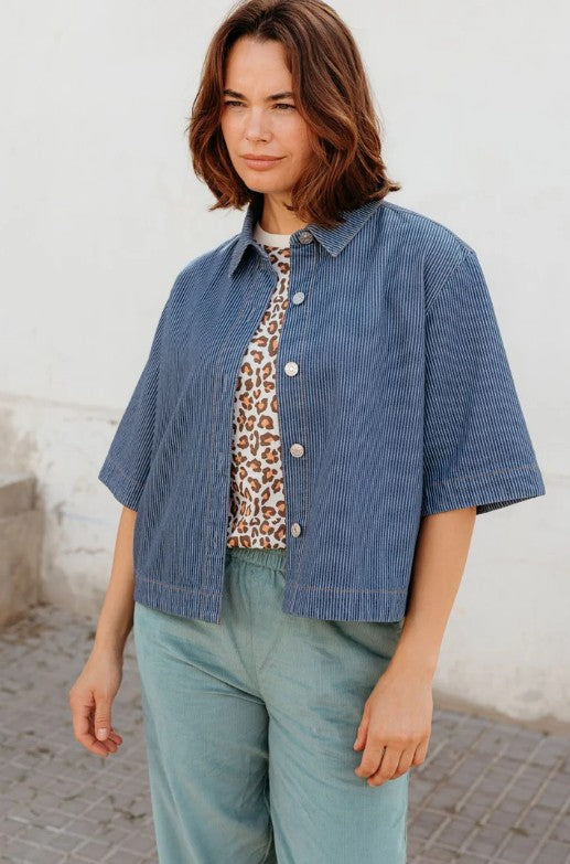Soft blue pinstripe denim jacket with short sleeves and silver buttons.