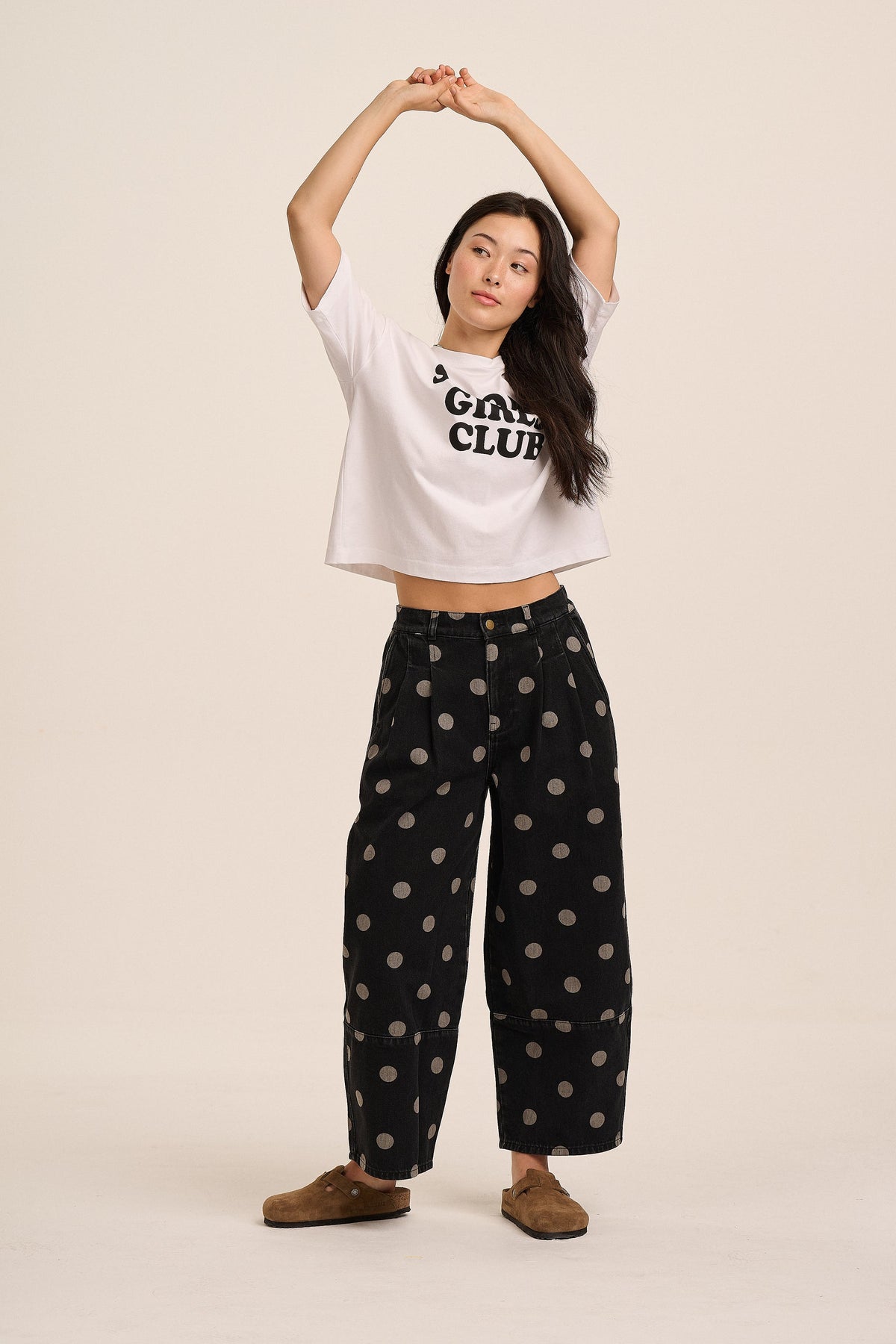 Black barrel leg jeans with taupe polka dot pattern.