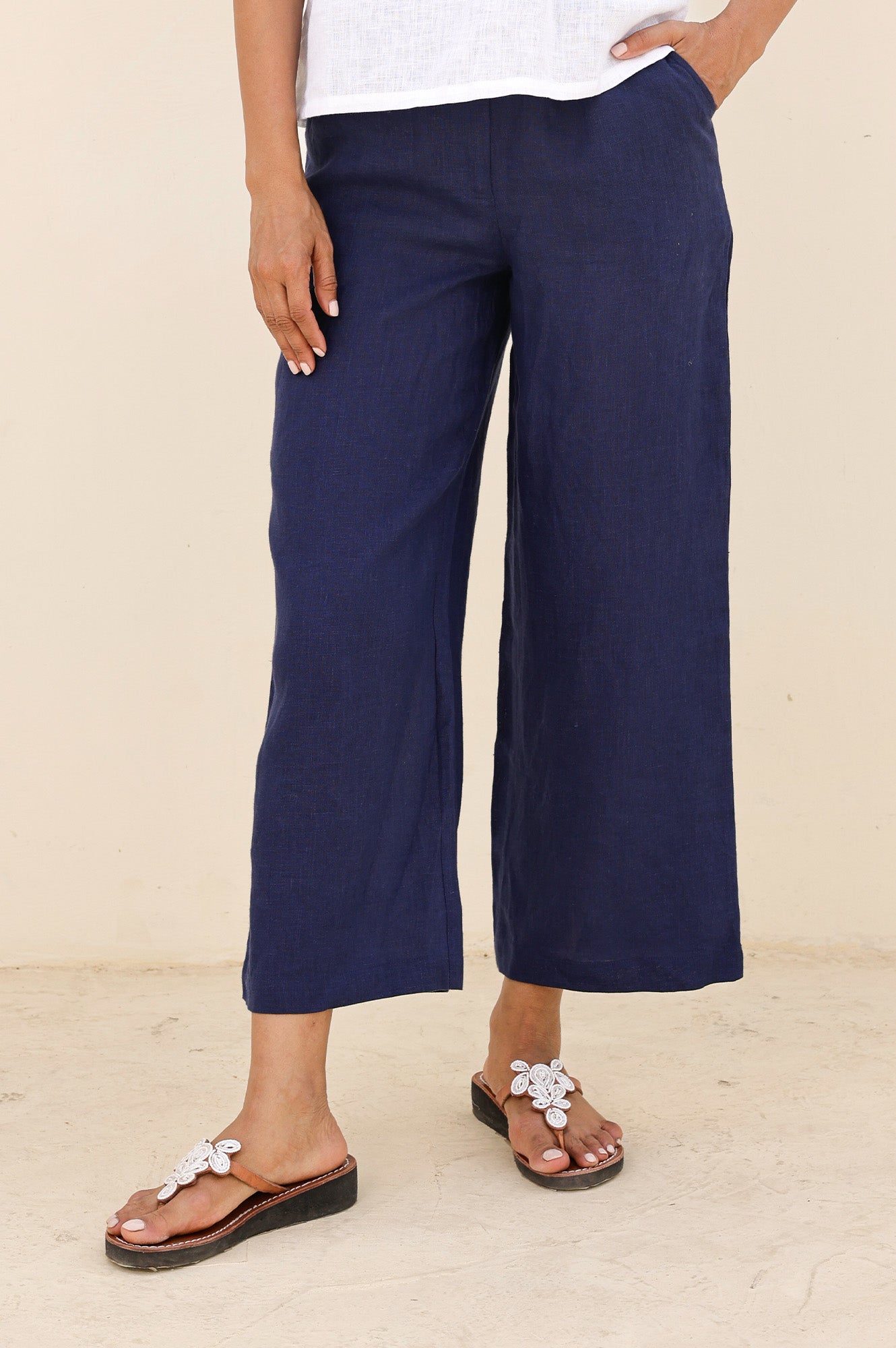 Navy linen wide-leg cropped trousers with flat front, relaxed fit, and ankle-length hem.