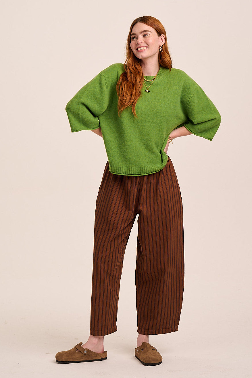 Brown pinstripe trousers with elasticated waist, tapered leg silhouette, and lightweight woven fabric.