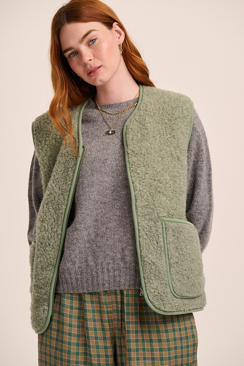 Light sage green fleece gilet with sleeveless design, zip front, patch pockets, and soft textured finish.