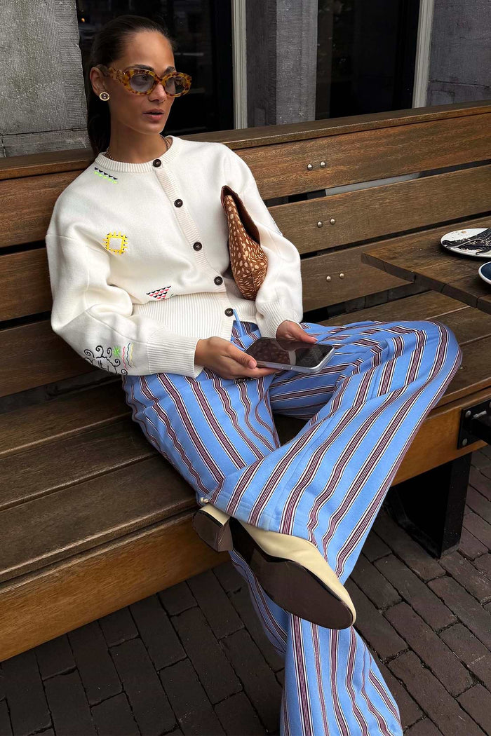 Light blue striped trousers with vertical brown and red pinstripes, straight leg fit, and tailored silhouette.