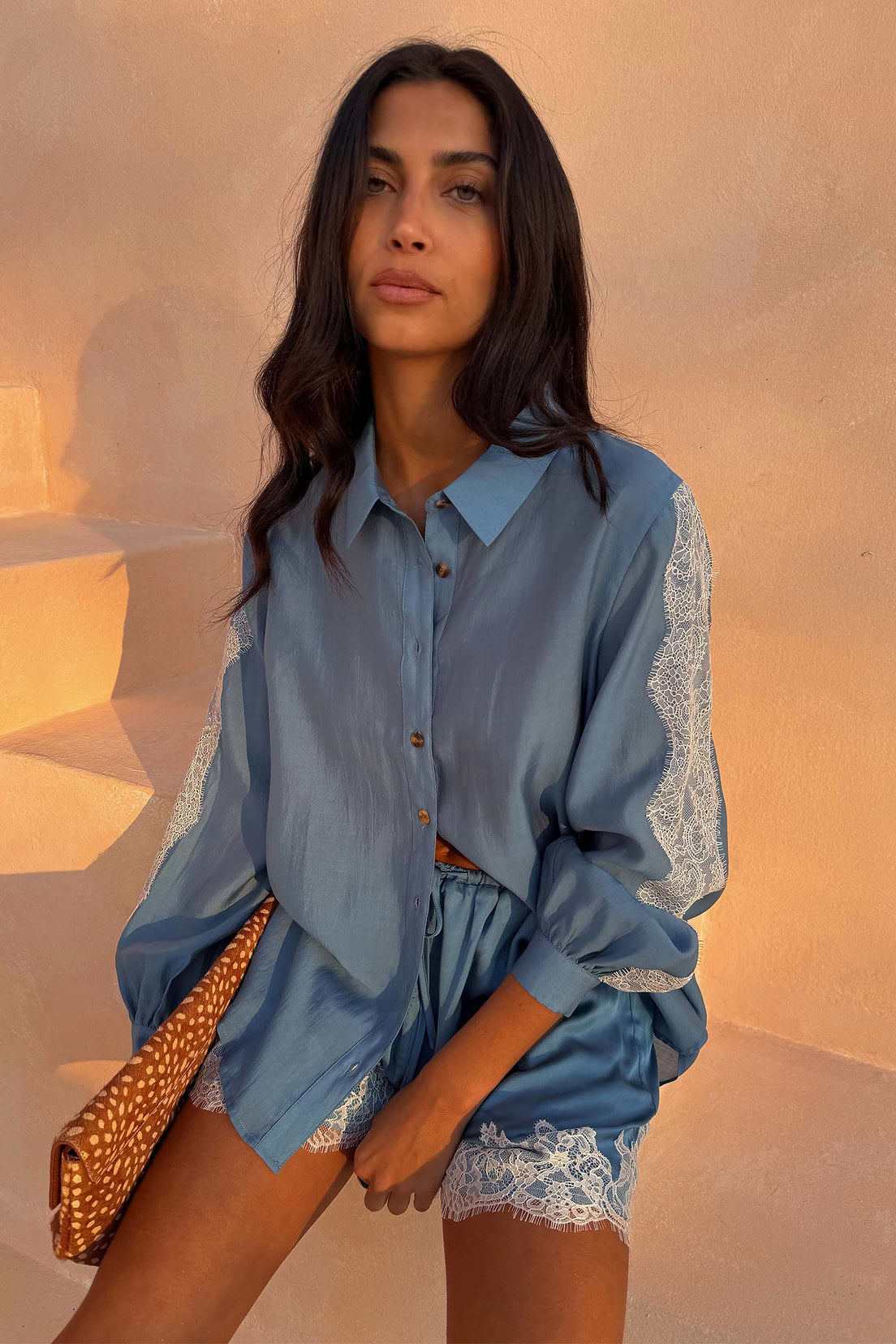 Blue satin shirt with lace trim.