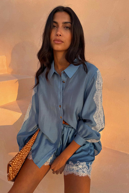 Blue satin shirt with lace trim.