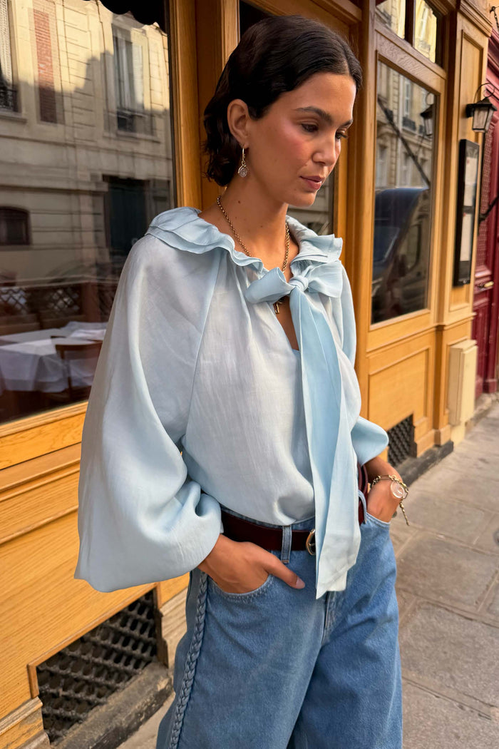 Ice blue ruffle neck blouse with balloon sleeves.
