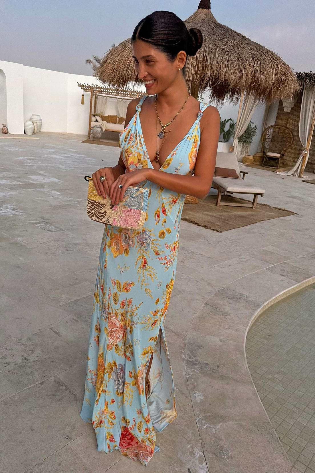 Light blue floral maxi dress with warm yellow and peach print, spaghetti straps, V-neckline, and flowing silhouette