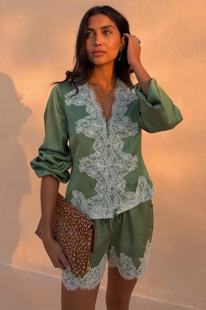Sage green satin blouse with lace trim.