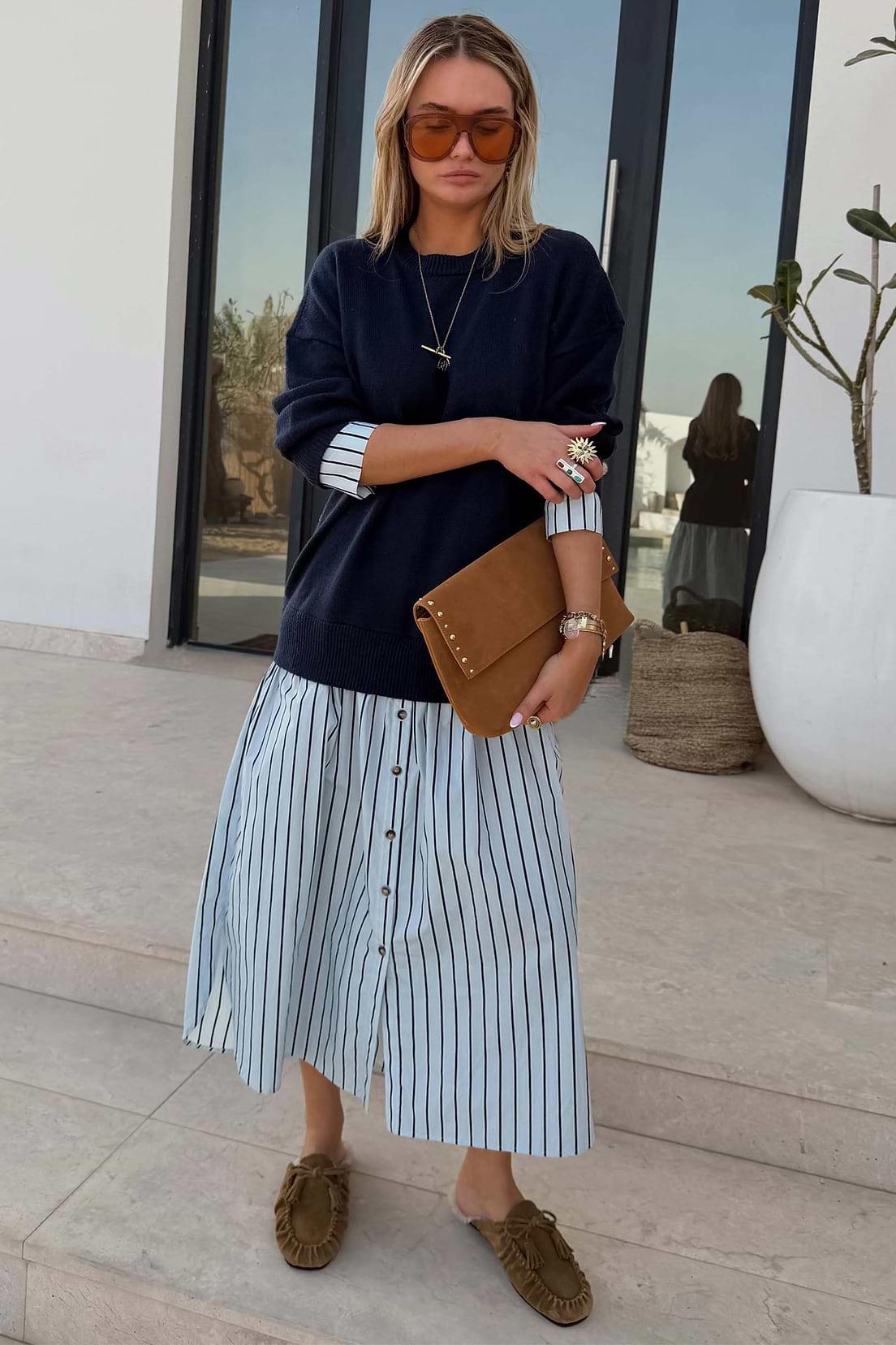 Deep navy knit jumper dress with relaxed fit, crew neckline, and ribbed hem and cuffs, and cotton skirt.