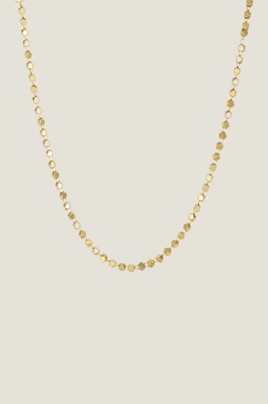 Gold choker necklace with small faceted bead detailing.