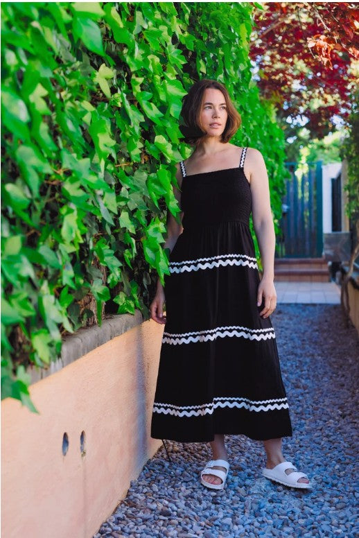 Black midi sundress with white ric rac straps and stripes.