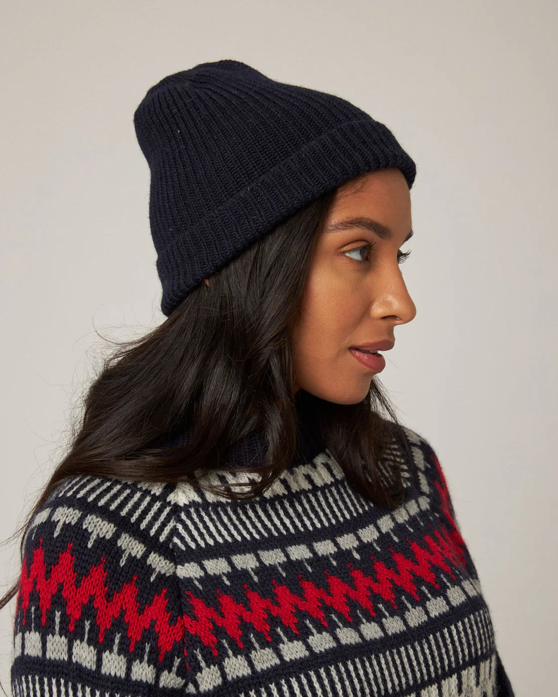 Model is wearing a dark navy knitted merino wool beanie by Peregrine Clothing, filtered for the Deep Winter or Dark Winter colour season by Shop My Palette.