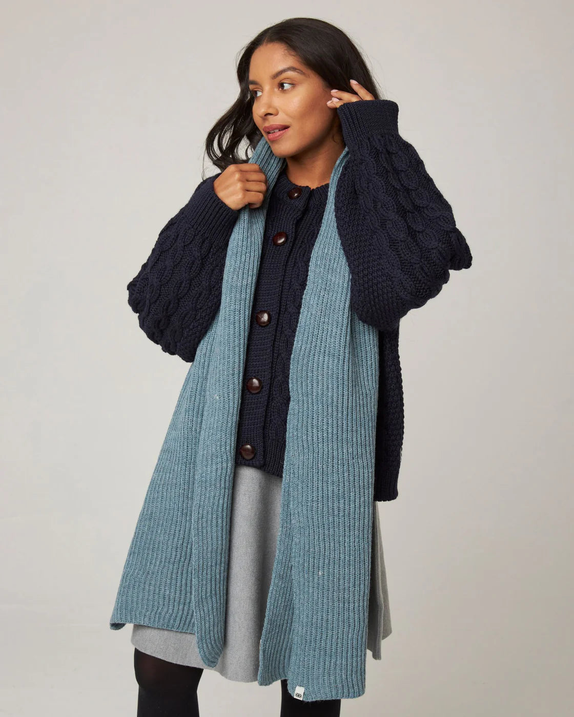 Model wears ribbed seafoam pale blue scarf in merino wool by Peregrine Clothing, filtered for the Light Summer, Cool Summer, and Soft Summer colour seasons.