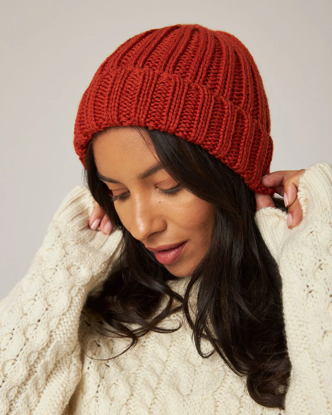 Model wears orange ribbed knit merino wool beanie hat by Peregrine Clothing, filtered for the Warm Autumn and Warm Spring colour seasons by Shop My Palette.