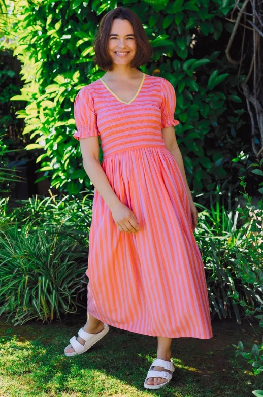 Coral and pink striped shirred midi dress with yellow v-neck trim.