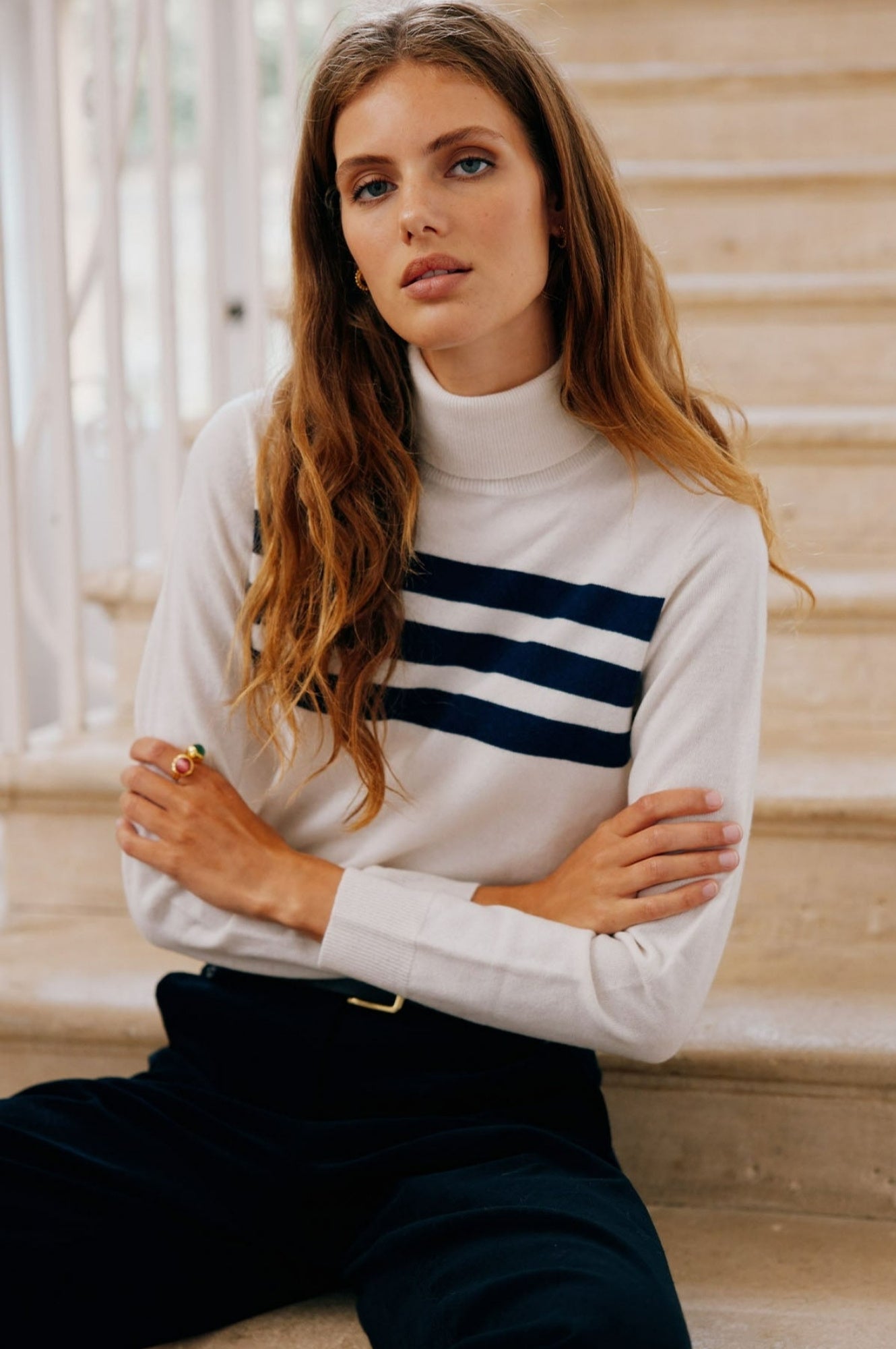Cream long-sleeve merino knit top with high neckline and navy stripe detail across the chest.