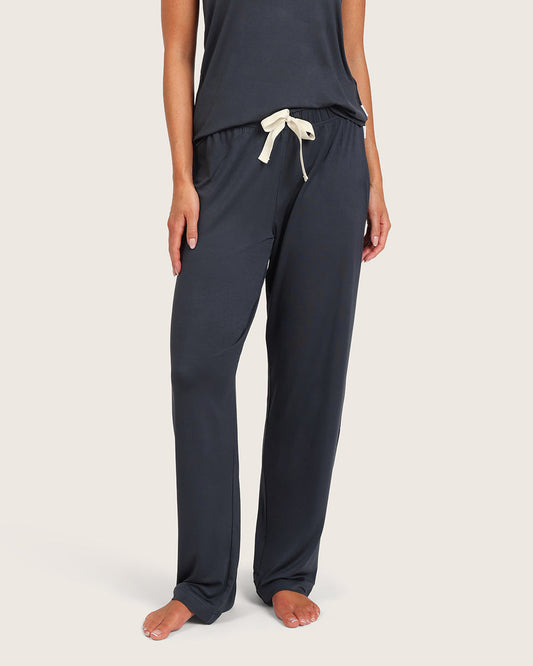 Grey-blue pyjama bottoms with a white drawstring on a beige background