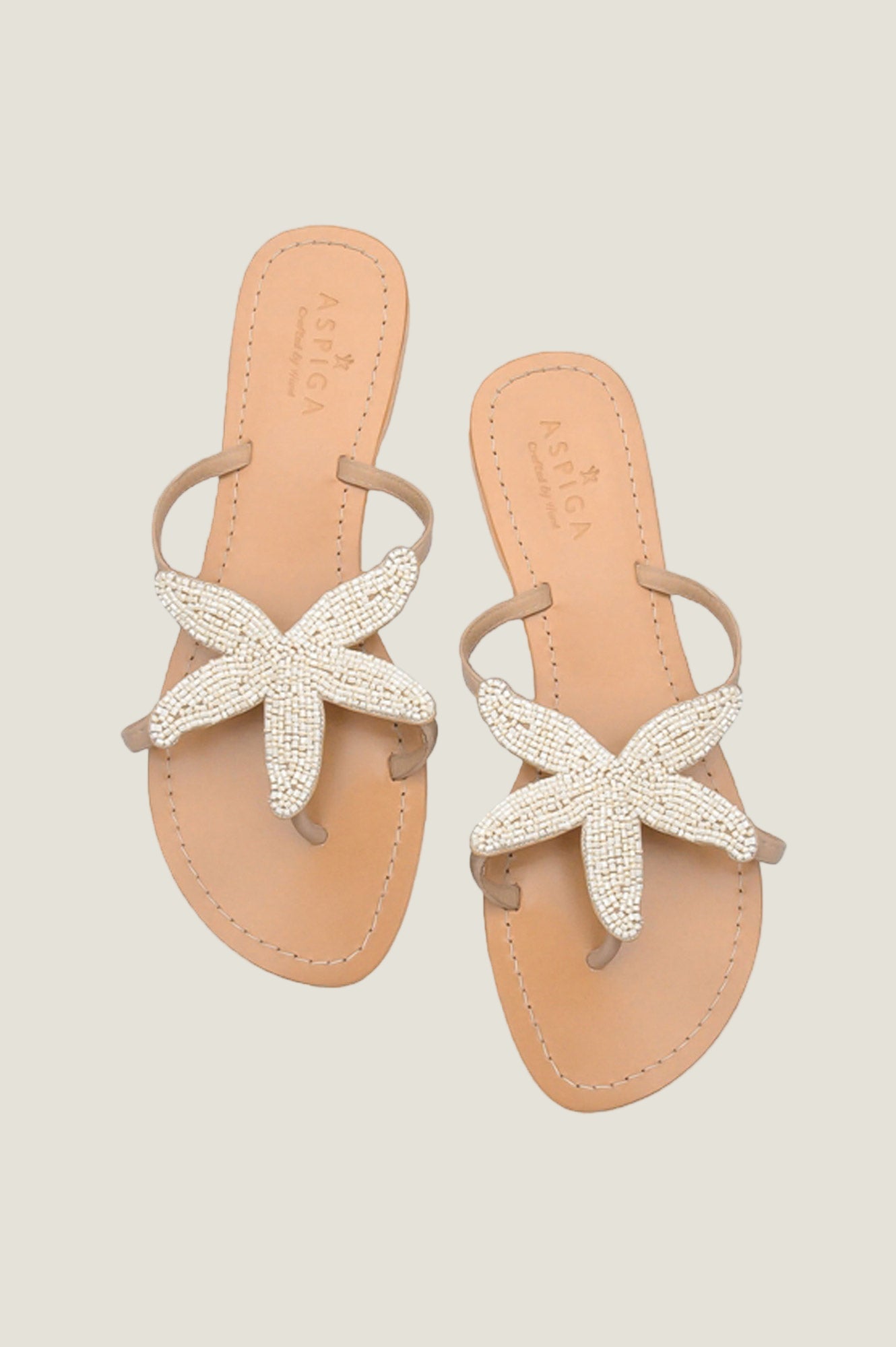 White beaded starfish leather sandals with tan sole, toe post, and slim ankle strap.