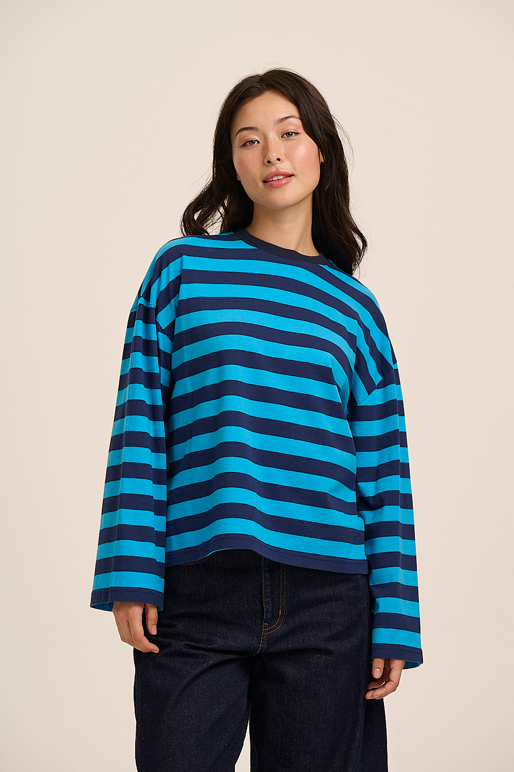 Woman wearing a wide striped blue and navy top.