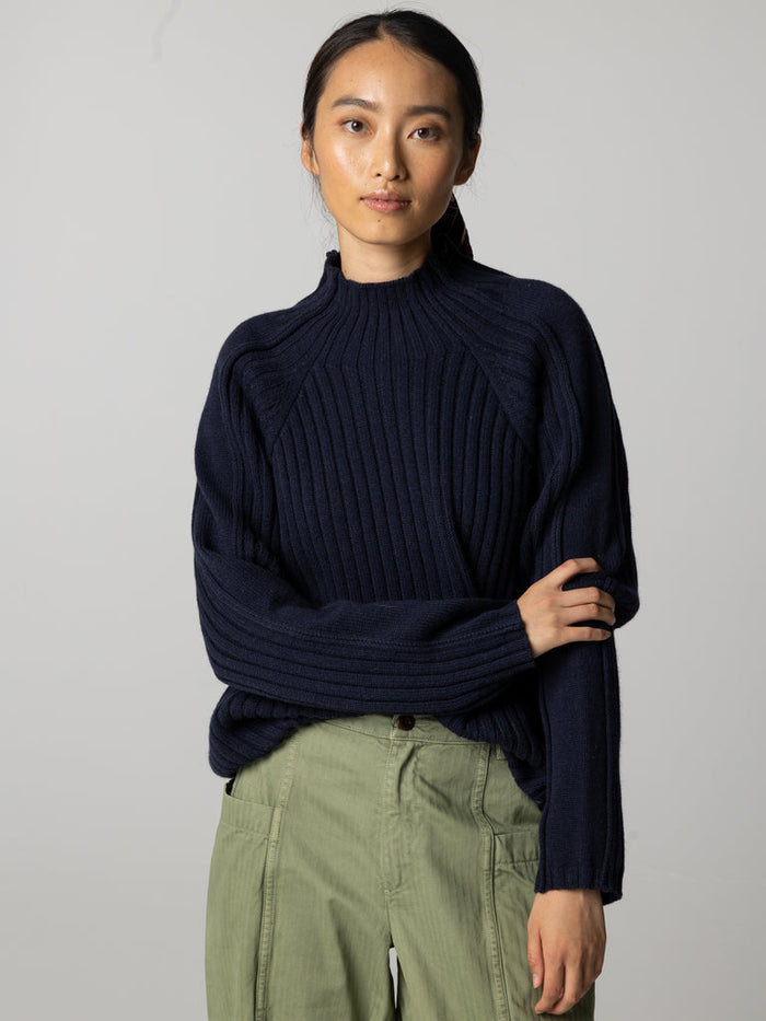 Navy blue ribbed high neck jumper.